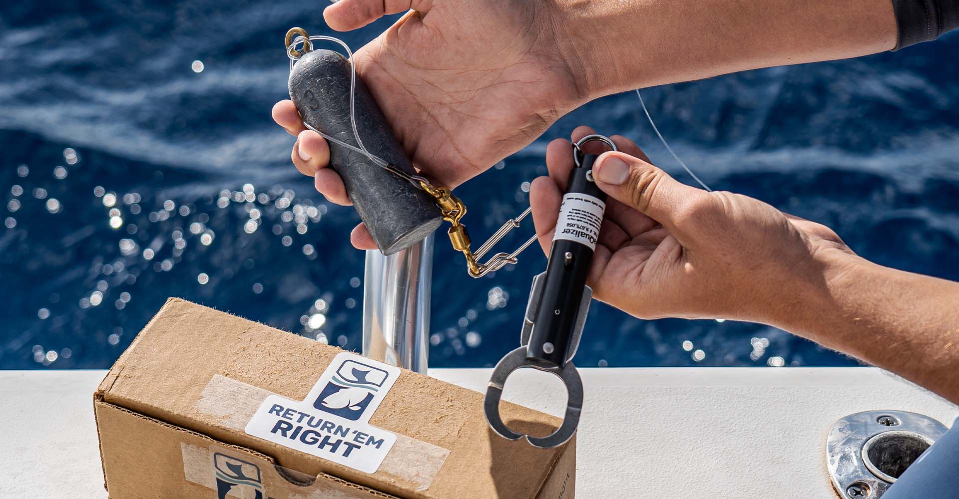 Photo of a person holding a fish descending device with a 3 pound weight over a cardboard box with a sticker on it that says Return 'Em Right