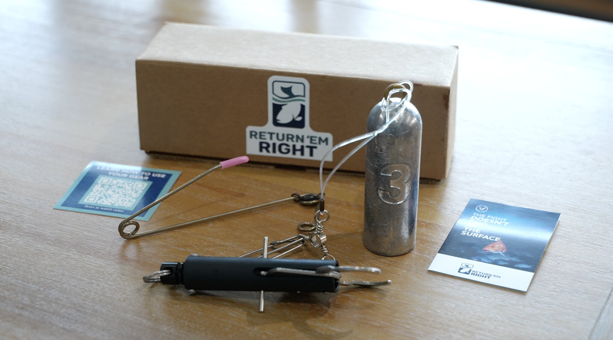 Photo displaying the package of gear received by Return 'Em Right anglers, including two types of descending device and print materials.